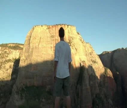 Man standing on mountain cliff, taking in view Stock Footage 21681262