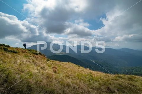 The man standing on the mountain on the cloud background Stock Photos