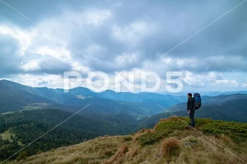 The man standing on the mountain on the cloud background Stock Photos