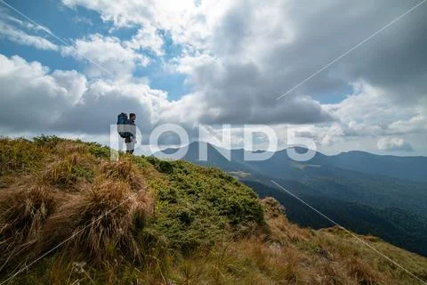 The man standing on the mountain on the cloud background Stock Photos