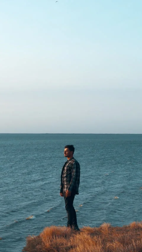 The man standing on the mountain edge above the sea Stock Footage 242138968