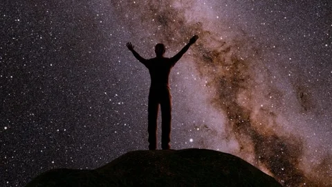 Man standing on mountain in front the milky way galaxy with open arms Stock Footage 284542256