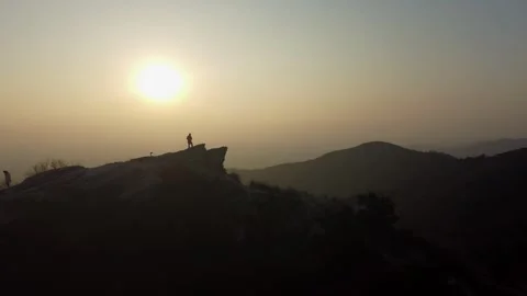 Man Standing on Mountain Peak Aerial Drone View with Majestic Nature Vista Stock Footage 326768829