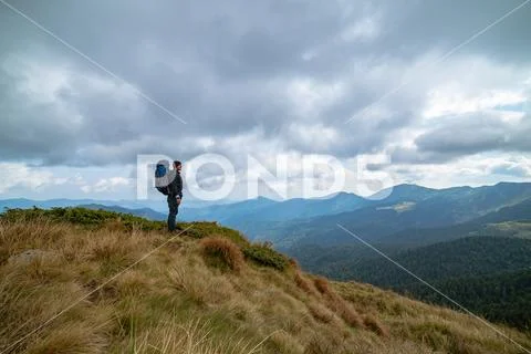 The man standing on the mountain on the rainy cloud background Stock Photos