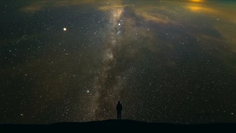 The man standing on a mountain on the starry sky background. time lapse Stock Footage 96288969
