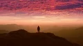 The man standing on a mountain top against the beautiful sunset 4k or 4k+ Resolution