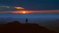 The man standing on the mountain top against the picturesque sunrise. time lapse 4k or 4k+ Resolution