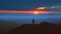 The man standing on the mountain top against a picturesque sunrise. time lapse 4k or 4k+ Resolution