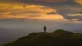 The man standing on a mountain top against the beautiful cloud stream 4k or 4k+ Resolution