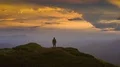 The man standing on a mountain top against a beautiful cloud stream 4k or 4k+ Resolution