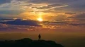 The man standing on a mountain top on a beautiful sunset background. time lapse 4k or 4k+ Resolution