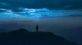 The man standing on a mountain top on the moolight background 4k or 4k+ Resolution