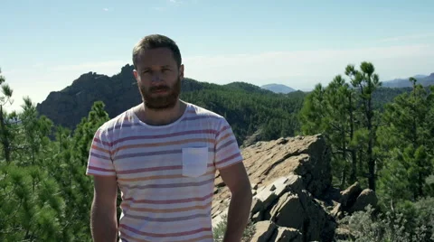 Man standing in the mountains and doing serious look to the camera 動画素材 60132251
