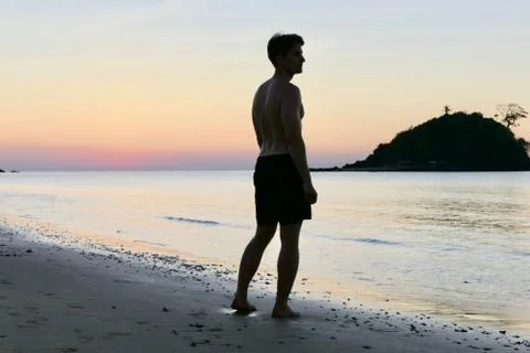 Man standing at Nacpan beach during sunset , before small island, Philippines Stock Photos