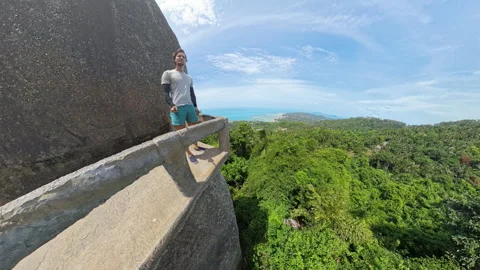 Man Standing on Narrow Platform at Overlap Stone on Koh Samui Surrounded by Stock Footage 313635350