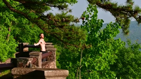 Man standing in natural background and soking in the sun Stock Footage 254796636
