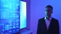 The man standing near a big displays in the blue room 4k or 4k+ Resolution