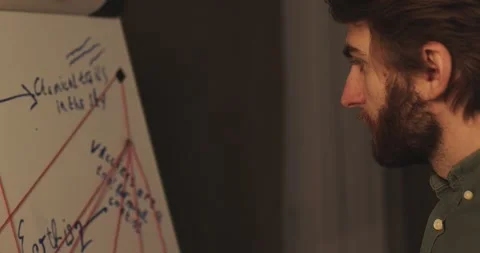 A man is standing near a crazy table on a conspiracy theory board. Stock Footage 272253683