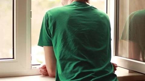 Man standing near an opened window Stock Footage 72814579