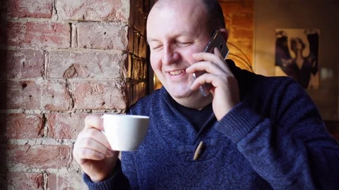 Man standing near a window in a cafe and drink coffee or tea, breakfast in Stock Footage 73127413
