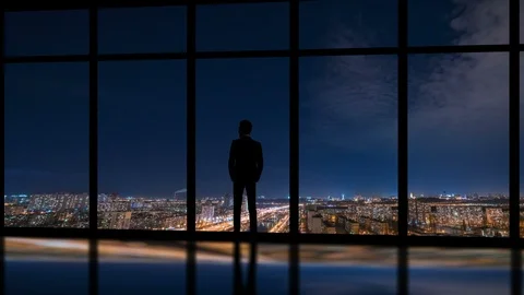 The man standing near window on a night city background. time lapse Stock Footage