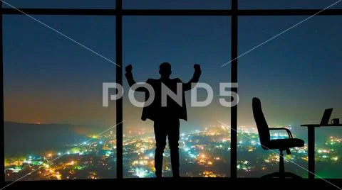 The man standing near the window on a night city background Stock Photos