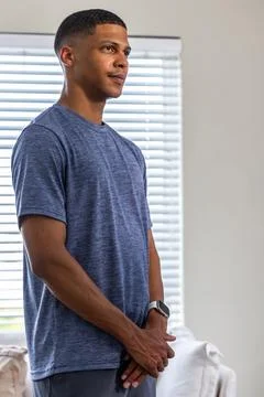 Man standing near window tapping smartwatch and showing animated controls over Stock Photos