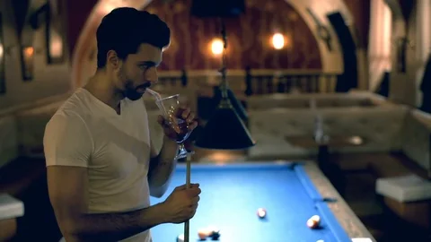 Man standing next to the billiard's table and drinking alcoholic beverage Stock-Footage 70126981
