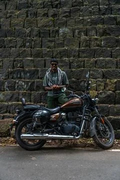 A man is standing next to a motorcycle Stock Photos