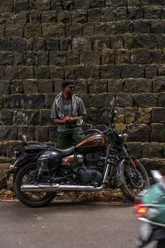 A man is standing next to a motorcycle Stock Photos