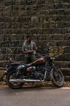 A man is standing next to a motorcycle Stock Photos