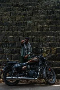 A man is standing next to a motorcycle Stock Photos