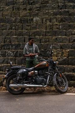 A man is standing next to a motorcycle Stock Photos