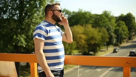 Man standing next to the road and having an argument while talking on cellphone Video stock 76978421