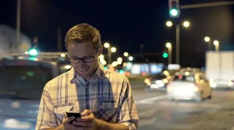 Man standing next to the road traffic and receiving good news, steadycam shot Stock-Footage 57411658