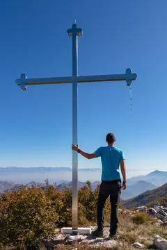 Man standing next to the summit cross of mountain Goli Vrh. Panoramic aeria.. Stock Photos