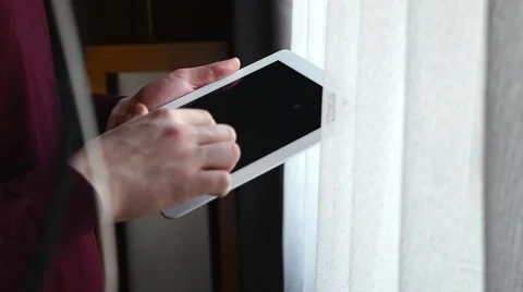 Man standing next to the window and using tablet pc. Close up. Stock Footage 61281634