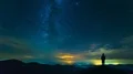 The man standing on a night mountain on the cloud stream background. time lapse 4k or 4k+ Resolution