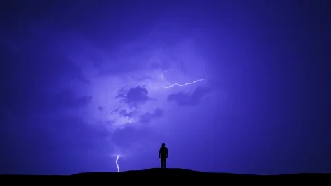The man standing on the night thunderstorm with lightning background Stock Footage 97387651