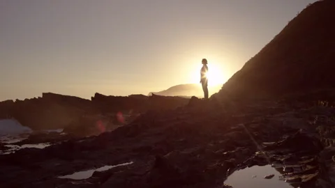 Man standing by the ocean at sunset Stock Footage 279800880