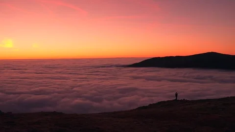 A man standing over a mountain cloud inversion in Snowdonia at sunrise Stock Footage 319672444