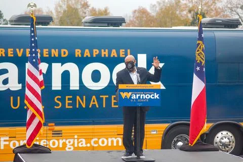 Man standing at podium in front of the "Warnock" bus Stock Photos