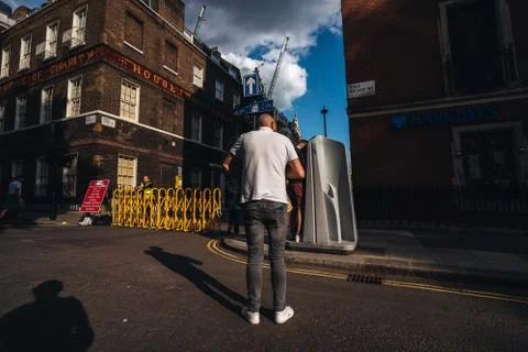 Man standing in the queue to use the public pissuar, urinal in Soho area. Stock Photos