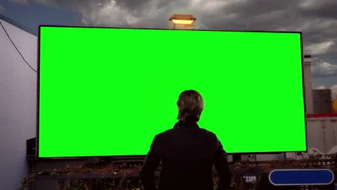 Man Standing Before Roadside Green Screen Billboard Mockup Stock Footage 342140124