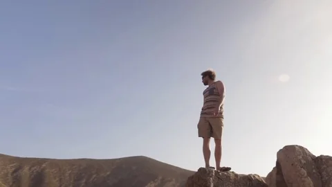 Man standing on rock and looking around on a sunny Day Video stock 71545427