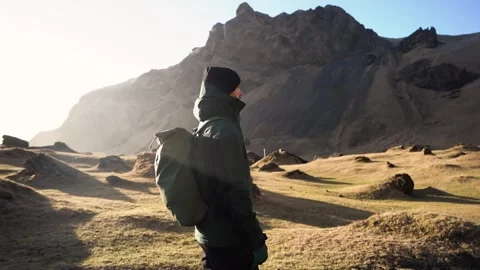 Man standing on rock with epic mountain viewpoint in Iceland Stock Footage 258261836