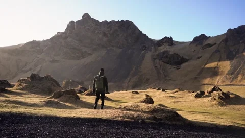Man standing on rock with epic mountain viewpoint in Iceland Stock Footage 258261908