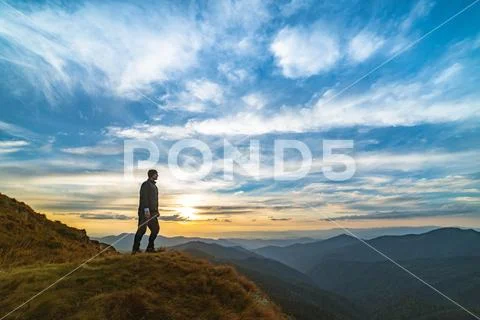 The man standing on the rock with a picturesque sunset Stock Photos