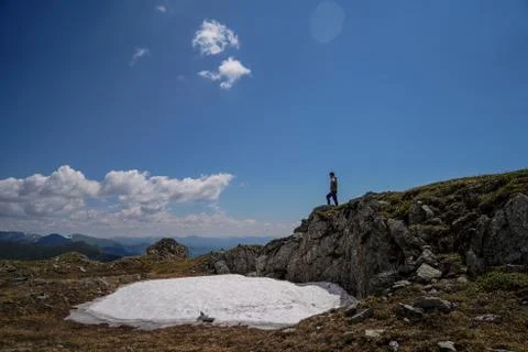 A man standing on rocks in front of sky background Stock Photos