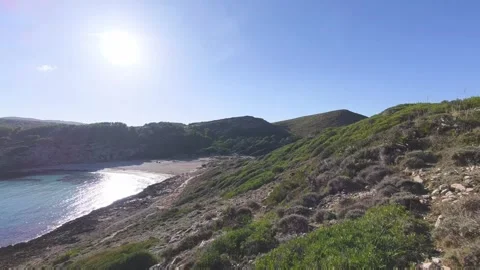 Man Standing on Rocky Cliff Overlooking Cala Torta Beach in Mallorca, Spain Vidéo 333019991